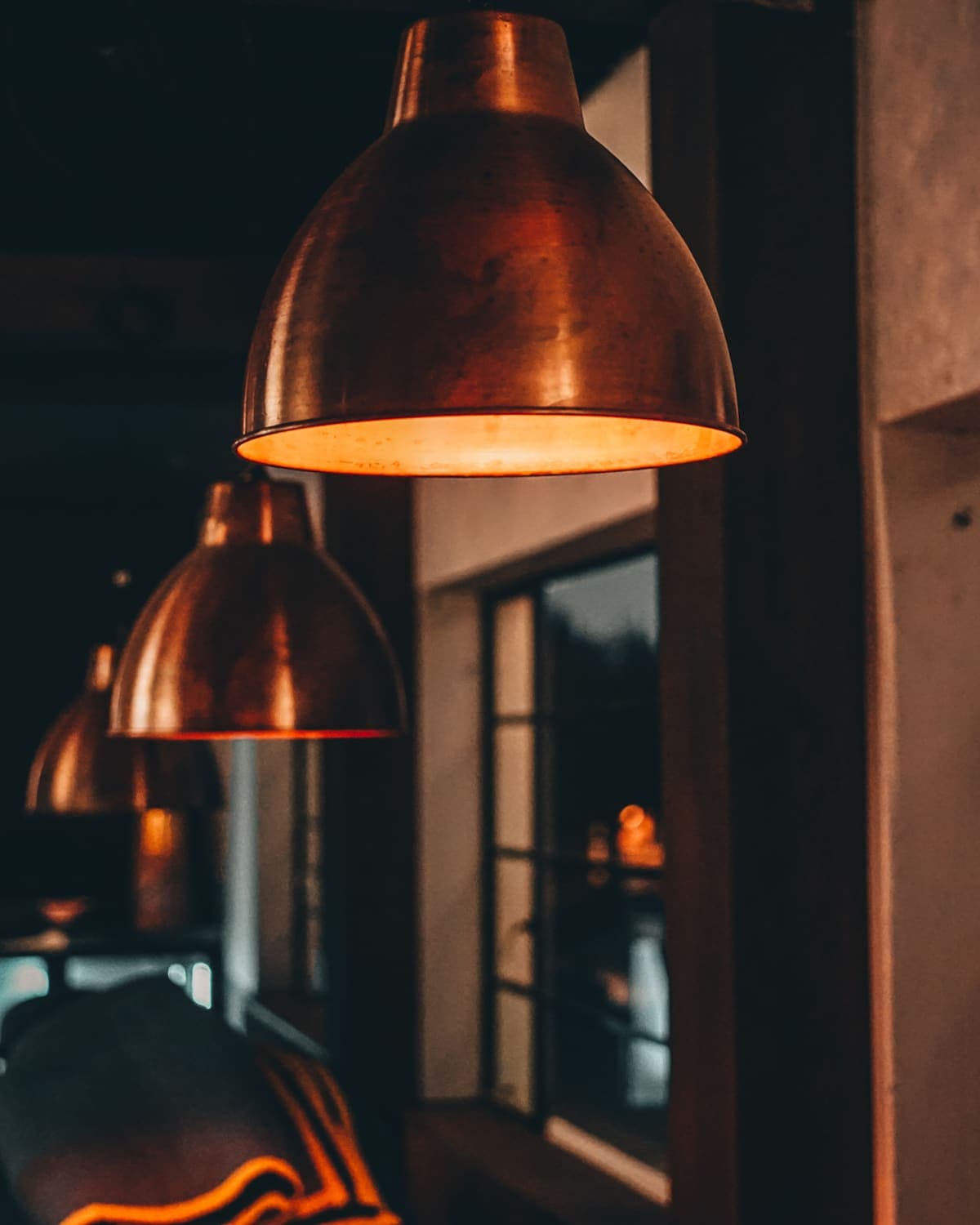 Copper lamps glowing in a row above The Inn's window seats