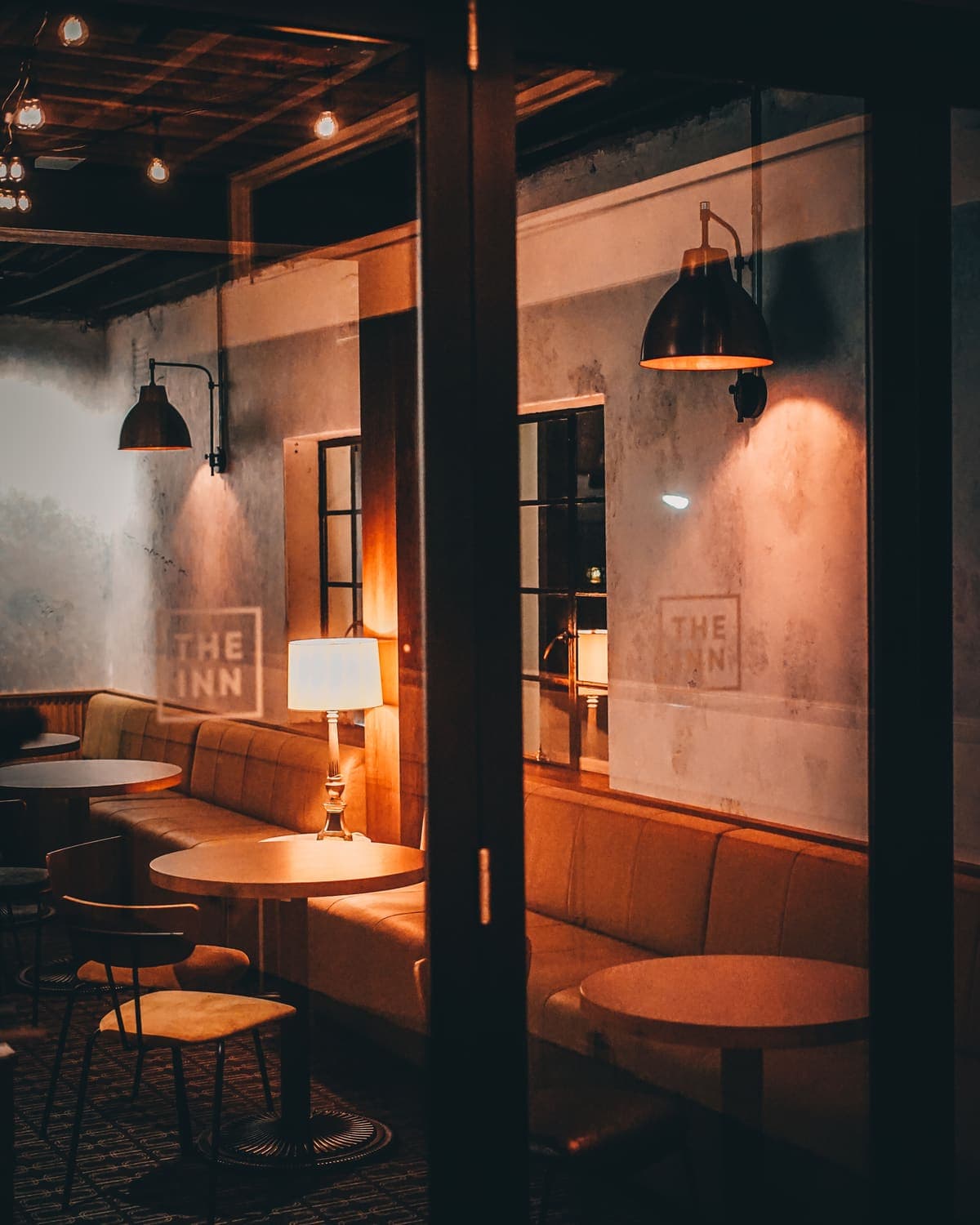 The lounge corner at The Inn, lamplit with the logo on the wall