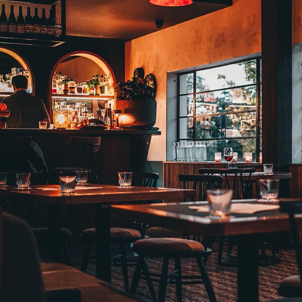 The Inn's lit bar and a window table at dusk
